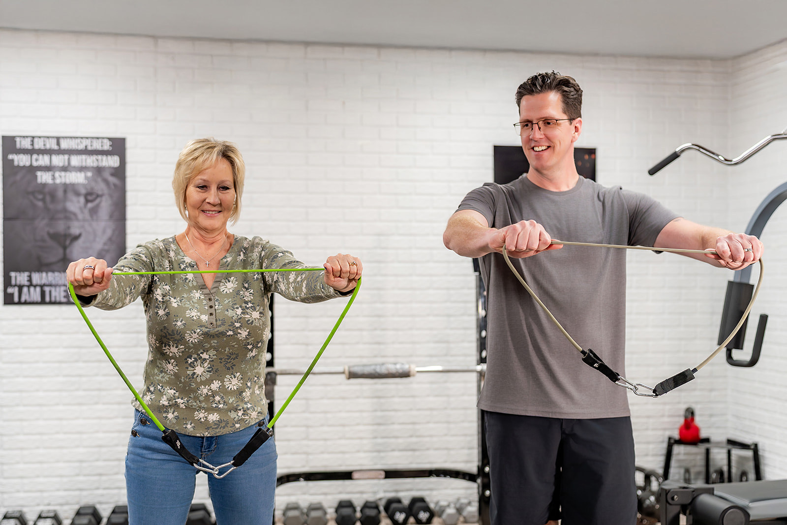 Doctor assisting older female patient with resistance band exercise